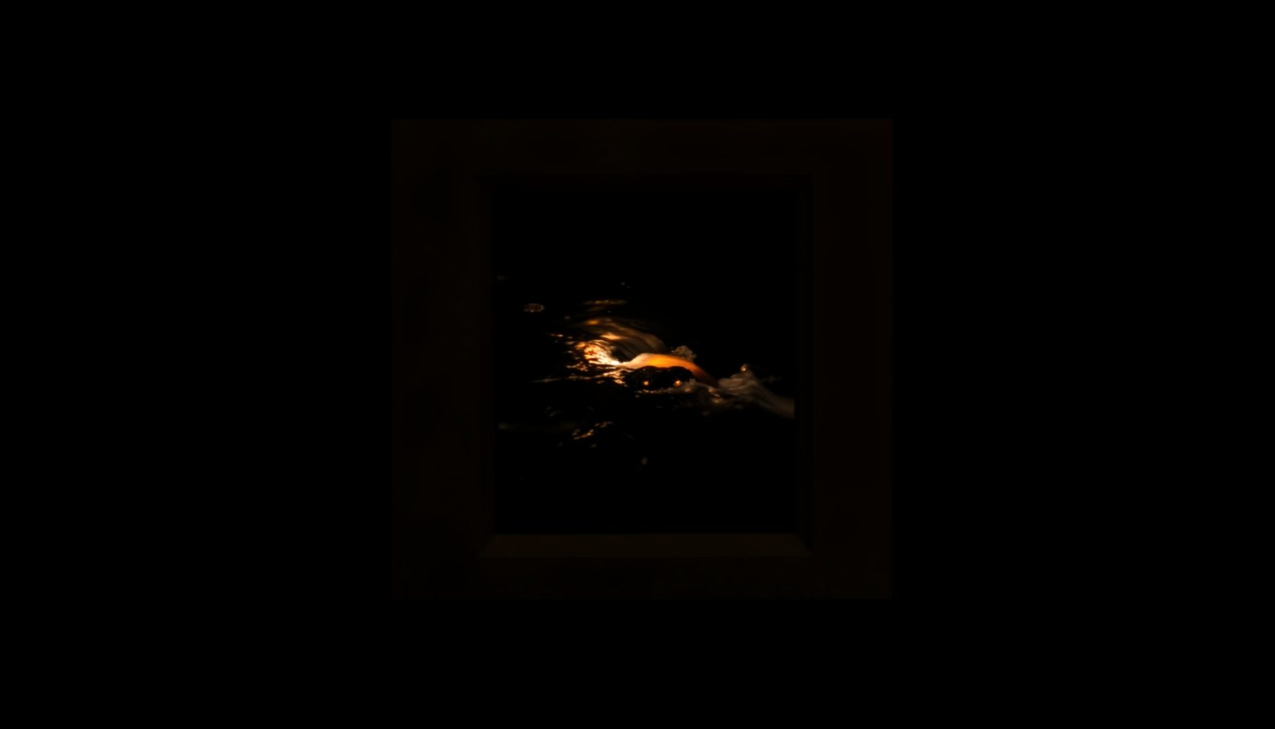 A small framed inset image of quiet flowing water in deep shadow, warm amber highlights catching the current